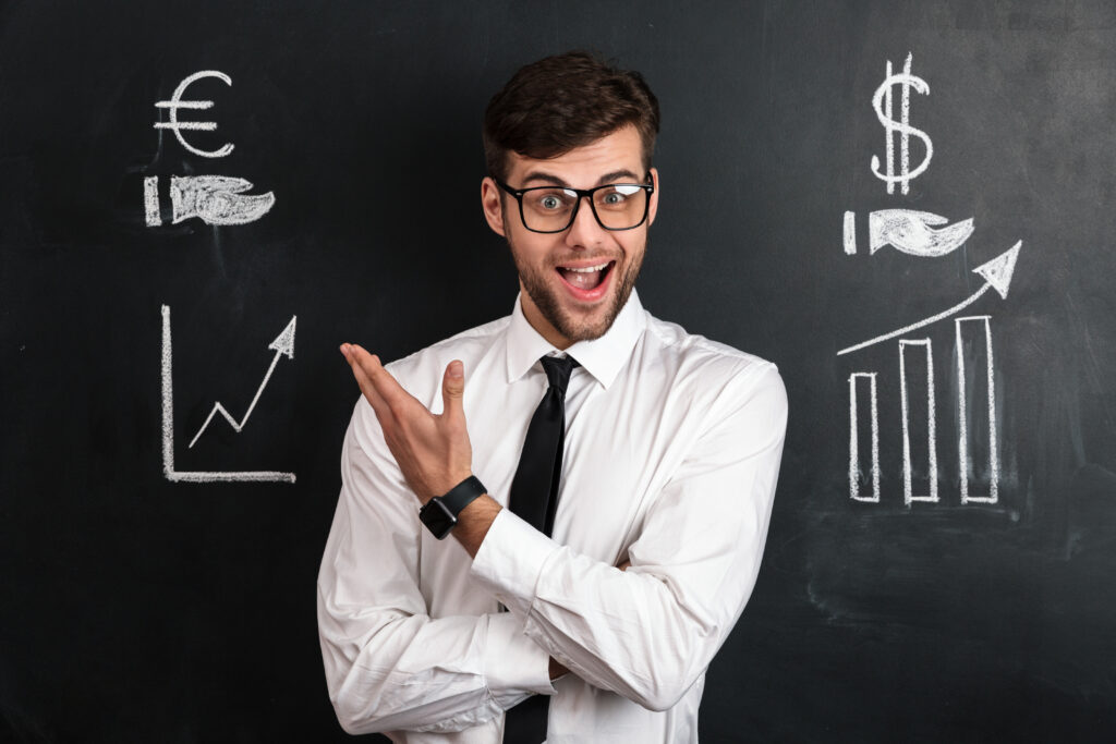 Happy successful businessman in white shirt presenting financial scheme, isolated on black chalkboard